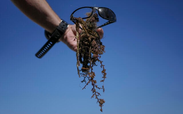 Trash, ghost nets, fishing lines, sunglasses collected by scuba-diving volunteers is on display during World Ocean Day event in the Mediterranean ancient Caesarea's Roman-period port, Israel, June 10, 2022. (AP Photo/Ariel Schalit)