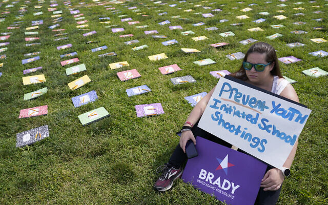 A woman listens to speakers during a rally near Capitol Hill in Washington, June 10, 2022, urging Congress to pass gun legislation. On display next to her are school notebooks representing children who have died from gun violence. (Susan Walsh/AP) A woman listens to speakers during a rally near Capitol Hill in Washington, June 10, 2022, urging Congress to pass gun legislation. On display next to her are school notebooks representing children who have died from gun violence. (Susan Walsh/AP)