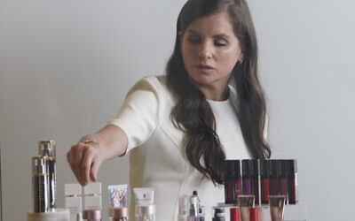 Revlon CEO Debra Perelman, the company's first woman CEO in its 89-year-old history, show products during an interview, August 18, 2021, in New York. (AP Photo/Bebeto Matthews, File)