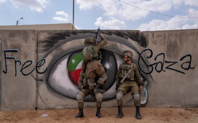 Israeli soldiers climb on a wall as they conduct a mock assault during an urban warfare exercise at an army training facility, in Tzeelim army base, southern Israel, Jan. 24, 2022. (Oded Balilty/AP)