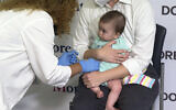 Ellen Fraint holds her daughter, seven-month-old Jojo, as she receives the first dose of the Moderna COVID-19 vaccine at Montefiore Medical Group in New York City on June 21, 2022. (AP Photo/Ted Shaffrey)