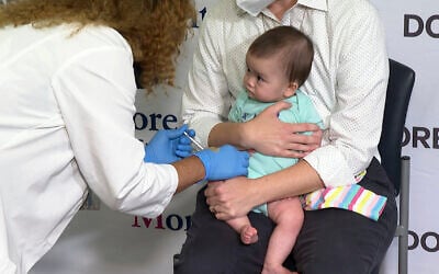 Ellen Fraint holds her daughter, seven-month-old Jojo, as she receives the first dose of the Moderna COVID-19 vaccine at Montefiore Medical Group in New York City on June 21, 2022. (AP Photo/Ted Shaffrey)