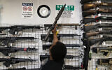 Illustrative: Sales associate Elsworth Andrews grabs an AR-15-style rifle to show it to a customer at Burbank Ammo & Guns in Burbank, California, June 23, 2022. (AP Photo/Jae C. Hong)