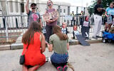 Anti-abortion activists Maggie Donica, 21, left, and Grace Rykaczewski, 21, kneel and pray in front of abortion-rights activists following the Supreme Court's decision to overturn Roe v. Wade, federally protected right to abortion, in Washington, Friday, June 24, 2022. (AP/Jacquelyn Martin)