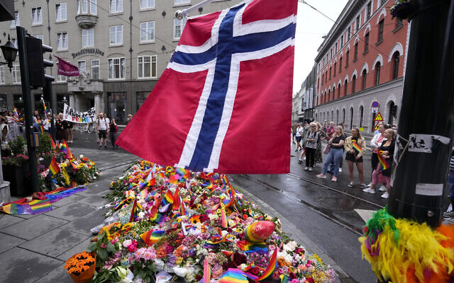 A Norwegian national flag flutters over flowers and rainbow flags that are placed at the scene of a shooting in central of Oslo, Norway, June 26, 2022. (AP Photo/Sergei Grits) A Norwegian national flag flutters over flowers and rainbow flags that are placed at the scene of a shooting in central of Oslo, Norway, June 26, 2022. (AP Photo/Sergei Grits)