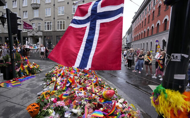 A Norwegian national flag flutters over flowers and rainbow flags that are placed at the scene of a shooting in central of Oslo, Norway, June 26, 2022. (AP Photo/Sergei Grits) A Norwegian national flag flutters over flowers and rainbow flags that are placed at the scene of a shooting in central of Oslo, Norway, June 26, 2022. (AP Photo/Sergei Grits)