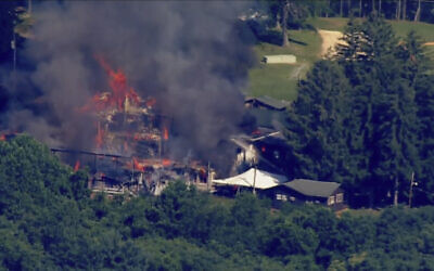 This image taken from video provided by WJLA shows crews battling a fire at Camp Airy for Boys in Thurmont, Md., on June 29, 2022. (WJLA via AP)