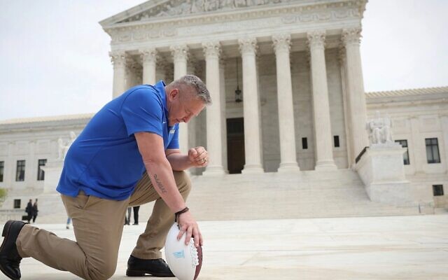 Former Bremerton High School assistant football coach Joe Kennedy takes a knee in front of the US Supreme Court after his legal case, Kennedy vs. Bremerton School District, was argued before the court, April 25, 2022. (Win McNamee/Getty Images via JTA) Former Bremerton High School assistant football coach Joe Kennedy takes a knee in front of the US Supreme Court after his legal case, Kennedy vs. Bremerton School District, was argued before the court, April 25, 2022. (Win McNamee/Getty Images via JTA)