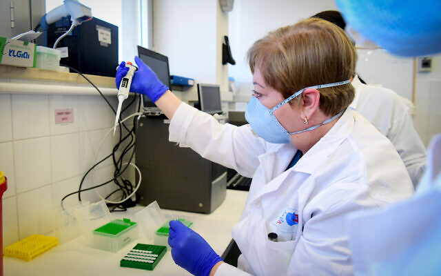 Illustrative: Medical staff at Barzilai Medical Center in Ashkelon handle a lab sample in March 2020 (Flash90) Illustrative: Medical staff at Barzilai Medical Center in Ashkelon handle a lab sample in March 2020 (Flash90)