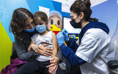 A young girl receives a dose of the COVID-19 vaccine in Jerusalem on December 30, 2021. (Olivier Fitoussi/Flash90)