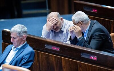 Ra'am party chief Mansour Abbas (L) speaks with his party MK Mazen Ghanaim (R) during a Knesset discussion on a bill to renew the application of some Israeli law to settlers, June 6, 2022. (Yonatan Sindel/Flash90)