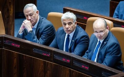 (R-L) Prime Minister Naftali Bennett, Foreign Minister Yair Lapid and Defense Minister Benny Gantz seen during a discussion and a vote on the 'West Bank bill' at the Knesset on June 6, 2022. (Yonatan Sindel/Flash90) (R-L) Prime Minister Naftali Bennett, Foreign Minister Yair Lapid and Defense Minister Benny Gantz seen during a discussion and a vote on the 'West Bank bill' at the Knesset on June 6, 2022. (Yonatan Sindel/Flash90)