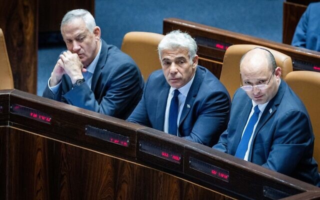 (R-L) Prime Minister Naftali Bennett, Foreign Minister Yair Lapid and Defense Minister Benny Gantz seen during a discussion and a vote on the 'West Bank bill' at the Knesset on June 6, 2022. (Yonatan Sindel/Flash90) (R-L) Prime Minister Naftali Bennett, Foreign Minister Yair Lapid and Defense Minister Benny Gantz seen during a discussion and a vote on the 'West Bank bill' at the Knesset on June 6, 2022. (Yonatan Sindel/Flash90)