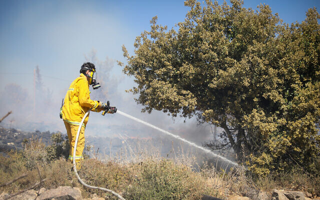 Firefighters try to extinguish a forest fire blazing near Kiryat Anavim, outside of Jerusalem, on June 8, 2022. (Noam Revkin Fenton/FLASH90) Firefighters try to extinguish a forest fire blazing near Kiryat Anavim, outside of Jerusalem, on June 8, 2022. (Noam Revkin Fenton/FLASH90)