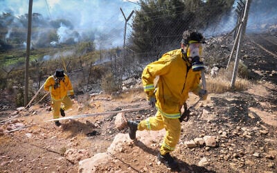 Firefighters try to extinguish a forest fire blazing near Kiryat Anavim, outside of Jerusalem, on June 08, 2022. (Noam Revkin Fenton/FLASH90)