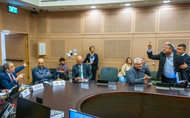 MK Gilad Kariv, left, motions as MK Itamar Ben Gvir is led out of a Knesset committee meeting on June 26, 2022. (Olivier FItoussi/Flash90) MK Gilad Kariv, left, motions as MK Itamar Ben Gvir is led out of a Knesset committee meeting on June 26, 2022. (Olivier FItoussi/Flash90)