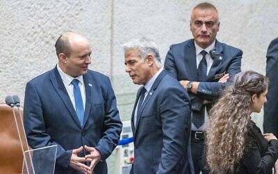 Prime Minister Naftali Bennett and Minister of Foreign Affairs Yair Lapid speak ahead of the first reading of a vote to dissolve the Knesset, on June 27, 2022. (Olivier Fitoussi/Flash90)