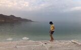 Illustrative image: An Israeli teen walks along a promenade into Israel's Dead Sea, 2021. (Amanda Borschel-Dan/ToI)