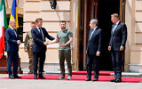 German Chancellor Olaf Scholz, left, watches Ukrainian President Volodymyr Zelensky shaking hands with French President Emmanuel Macron, second left, as Romanian President Klaus Iohannis, right, and Italian Prime Minister Mario Draghi look on, in Kyiv, June 16, 2022. (Ludovic Marin, Pool via AP)