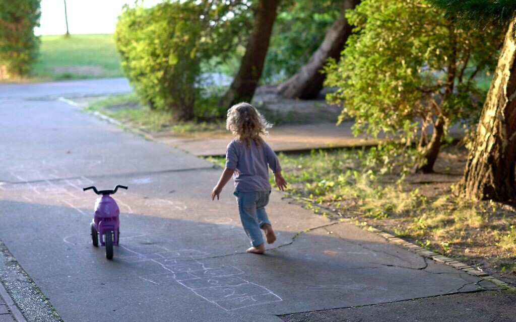 A child plays near the lake near a camp for Ukrainian Jewish refugees in Balatonőszöd, Hungary, in June 2022. (Courtesy of EMIH)