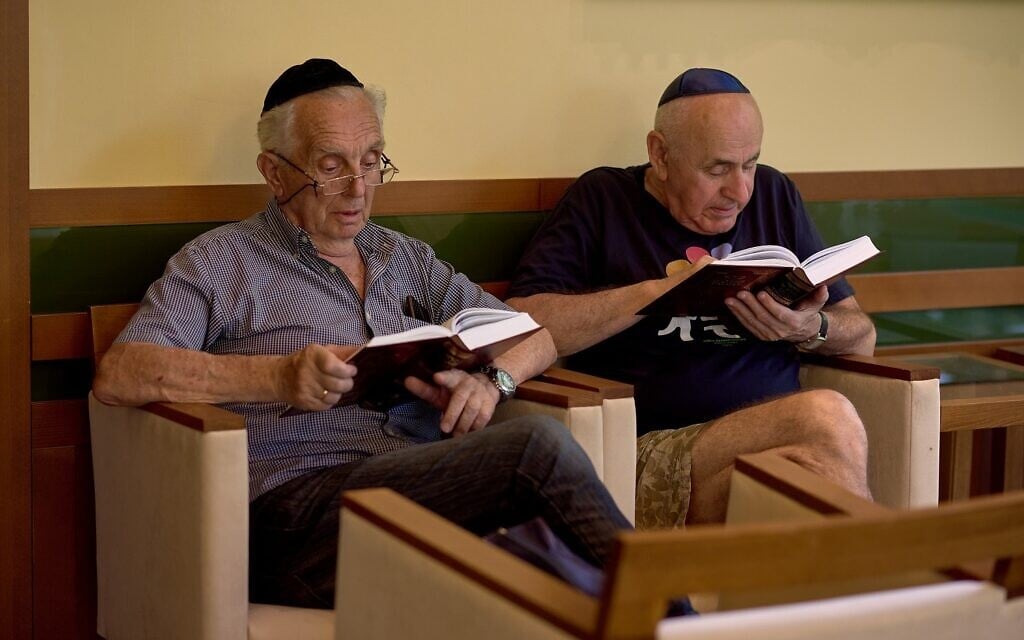 Men read in a camp for Ukrainian Jewish refugees in Balatonőszöd, Hungary, in June 2022. (Courtesy of EMIH)