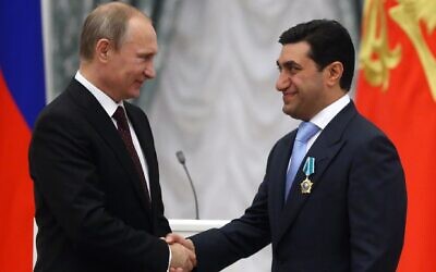 Russian President Vladimir Putin, left, shakes hands with Russian businessman and billionaire God Nisanov in the Kremlin in Moscow, Russia, July 31, 2014. (Sasha Mordovets/Getty Images via JTA)