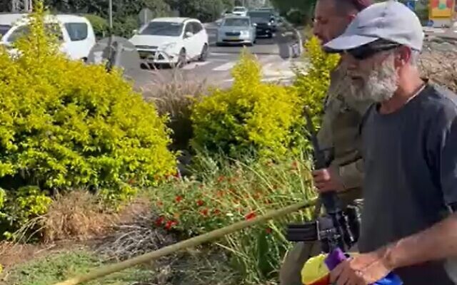 Two men, one in an IDF uniform, seen pulling down a pride flag in northern Israel on June 23, 2022. (Screenshot) Two men, one in an IDF uniform, seen pulling down a pride flag in northern Israel on June 23, 2022. (Screenshot)