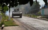 Ukrainian soldiers ride an armoured vehicle on the main road to Lysychansk in Ukraine's eastern region of Donbas on June 26, 2022. (Bagus Saragih/AFP)
