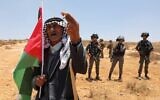A Palestinian demonstrator blocks the road in front of Israeli soldiers in the Masafer Yatta area in the West Bank, which has been at the center of a protracted legal battle, July 1, 2022. (Mosab Shawer/AFP)