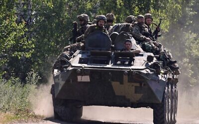 Ukrainian soldiers on top of an Ukrainian armoured fighting vehicle are pictured on a road in the countryside of Siversk, in Donetsk Oblast, eastern Ukraine, on July 8, 2022, amid the Russian invasion of Ukraine. (MIGUEL MEDINA / AFP)