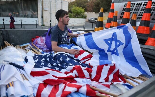 A worker prepares Israeli and US flags on July 12, 2022, in Jerusalem, ahead of US President Joe Biden's visit to Israel. (PAHMAD GHARABLI / AFP) A worker prepares Israeli and US flags on July 12, 2022, in Jerusalem, ahead of US President Joe Biden's visit to Israel. (PAHMAD GHARABLI / AFP)