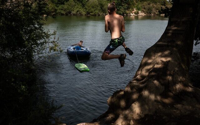 A teenager dives into an artificial lake in Lavau-sur-Loire, western France, on July 17, 2022 as a heatwave hits France (Loic VENANCE / AFP) A teenager dives into an artificial lake in Lavau-sur-Loire, western France, on July 17, 2022 as a heatwave hits France (Loic VENANCE / AFP)