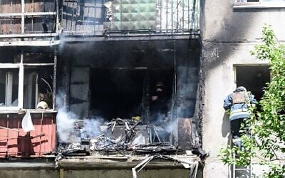 Firemen intervene after extinguishing a fire in a building after an air strike hit the courtyard of civilian residences in the center of Kramatorsk, eastern Ukraine, July 19, 2022. (Miguel Medina/AFP)