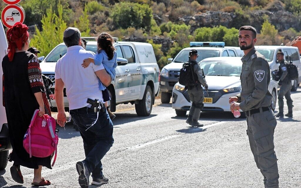 Border police stand guard as settlers gather to establish an illegal outpost near Talmon in the West Bank on July 20, 2022. (GIL COHEN-MAGEN / AFP) Border police stand guard as settlers gather to establish an illegal outpost near Talmon in the West Bank on July 20, 2022. (GIL COHEN-MAGEN / AFP)