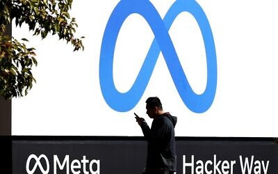 A pedestrian walks in front of a new logo and the name 'Meta' on the sign in front of Facebook headquarters in Menlo Park, California, on October 28, 2021. (Justin Sullivan/ Getty Images North America/ AFP/ File)