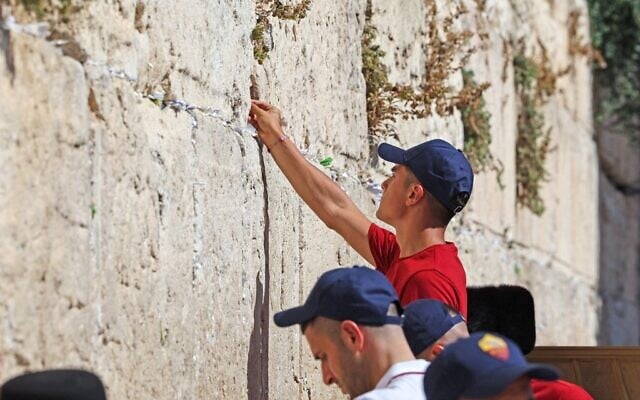 AS Roma's Argentinian striker Paulo Dybala places a note as he prays by the Western Wall in Jerusalem's Old City on July 29, 2022, during a visit alongside his teammates on the eve of their friendly football match with Tottenham Hotspur in the Israeli city of Haifa. (Ahmad Gharabli/AFP) AS Roma's Argentinian striker Paulo Dybala places a note as he prays by the Western Wall in Jerusalem's Old City on July 29, 2022, during a visit alongside his teammates on the eve of their friendly football match with Tottenham Hotspur in the Israeli city of Haifa. (Ahmad Gharabli/AFP)