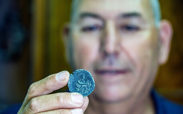Israel Antiquities Authority Maritime Archaeology Unit Director Jacob Sharvit holding the coin (Yaniv Berman/Israel
Antiquities Authority)