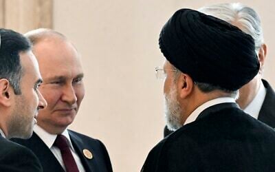 Russian President Vladimir Putin, left, speaks to Iran's President Ebrahim Raisi, back to a camera, on the sideline of the summit of Caspian Sea littoral states in Ashgabat, Turkmenistan, June 29, 2022. (Grigory Sysoyev, Sputnik, Kremlin Pool Photo via AP, File)