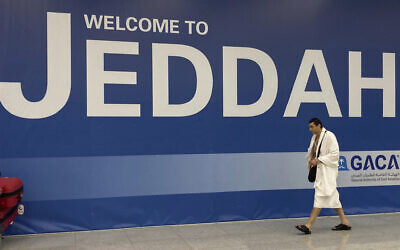 A Muslim pilgrim walks in front of a welcoming banner upon his arrival at the King Abdulaziz International Airport in Jeddah, Saudi Arabia, Friday, July 1, 2022. (AP Photo/Amr Nabil)