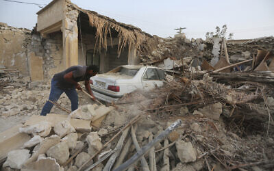 A man cleans up the rubble after an earthquake at Sayeh Khosh village in Hormozgan province, some 620 miles (1,000 kilometers) south of the capital, Tehran, Iran, July 2, 2022. (AP Photo/Abdolhossein Rezvani)