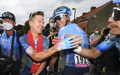 Stage winner Australia's Simon Clarke, second left, is congratulated by teammate Britain's Chris Froome, center, and another member of Israel Premier Tech after crossing the finish line of the fifth stage of the Tour de France cycling race in Arenberg Porte du Hainaut, France, July 6, 2022. (Tim De Waele/Pool Photo via AP)