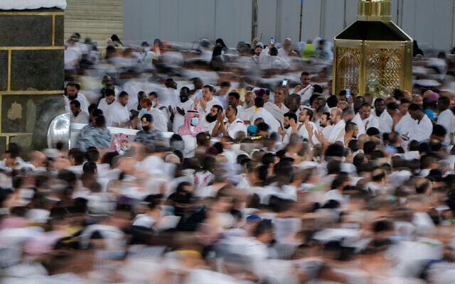 In this photo taken with low shutter speed, Muslim pilgrims pray as others circumambulate around the Kaaba, the cubic building at the Grand Mosque, in Mecca, Saudi Arabia, July 6, 2022. (Amr Nabil/AP)