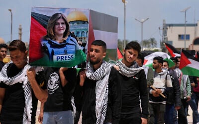 Students carry a mock coffin as they hold a symbolic funeral for slain Al Jazeera journalist Shireen Abu Akleh, at al-Azhar University in Mughraqa, central Gaza Strip, May 16, 2022. (AP Photo/Adel Hana, File)
