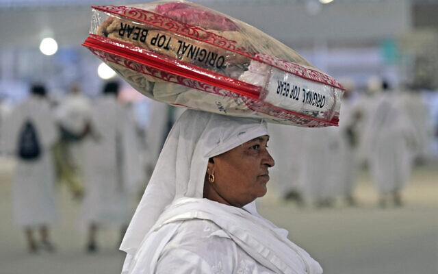 A woman Muslim pilgrim carries her belongings on her head during the Hajj pilgrimage, in Mina near the city of Mecca, Saudi Arabia, July 9, 2022. (AP Photo/Amr Nabil) A woman Muslim pilgrim carries her belongings on her head during the Hajj pilgrimage, in Mina near the city of Mecca, Saudi Arabia, July 9, 2022. (AP Photo/Amr Nabil)