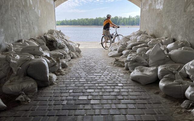 A Sunday morning cyclist emerges from a sandbagged tunnel next to the Dnipro River in Kyiv, Ukraine, July 10, 2022. (AP Photo/Cara Anna) A Sunday morning cyclist emerges from a sandbagged tunnel next to the Dnipro River in Kyiv, Ukraine, July 10, 2022. (AP Photo/Cara Anna)