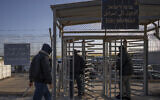 File: Palestinian workers enter Israel after crossing from Gaza, on the Israeli side of Erez crossing between Israel and the Gaza Strip, March 27, 2022. (AP Photo/Oded Balilty)