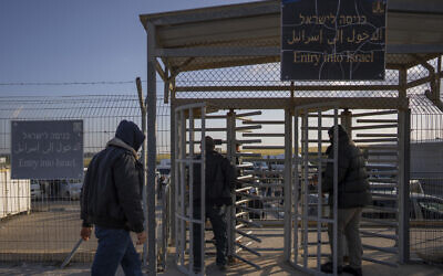 File: Palestinian workers enter Israel after crossing from Gaza, on the Israeli side of Erez crossing between Israel and the Gaza Strip, March 27, 2022. (AP Photo/Oded Balilty)