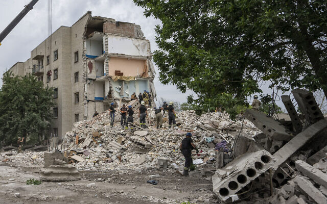 Rescue workers stand on the rubble at the scene in the after math of a missile strike that his a residential apartment block, in Chasiv Yar, Donetsk region, eastern Ukraine, July 10, 2022. (AP Photo/Nariman El-Mofty) Rescue workers stand on the rubble at the scene in the after math of a missile strike that his a residential apartment block, in Chasiv Yar, Donetsk region, eastern Ukraine, July 10, 2022. (AP Photo/Nariman El-Mofty)