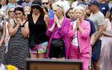 Four women join local residents for a two-minute moment of silence at 10:14 a.m. at the Highland Park, Illinois memorial commemorating the seven people who lost their lives during the town's Fourth if July parade, July 11, 2022. (AP Photo/Charles Rex Arbogast)