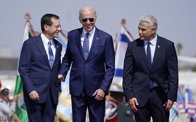 US President Joe Biden stands with Prime Minister Yair Lapid, right, and President Isaac Herzog, left, after arriving at Ben Gurion Airport, July 13, 2022. (AP Photo/Evan Vucci) US President Joe Biden stands with Prime Minister Yair Lapid, right, and President Isaac Herzog, left, after arriving at Ben Gurion Airport, July 13, 2022. (AP Photo/Evan Vucci)
